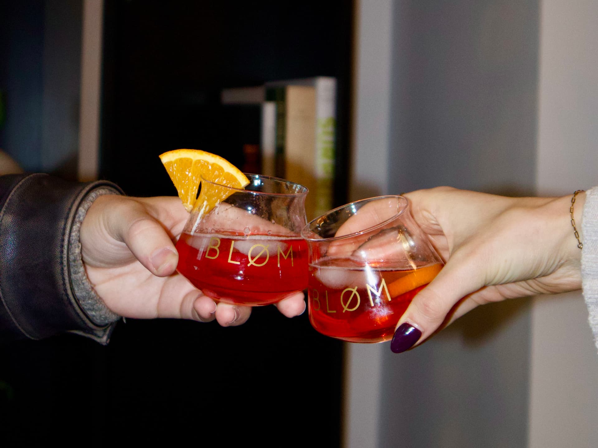 Two hands toasting with Bløm glasses