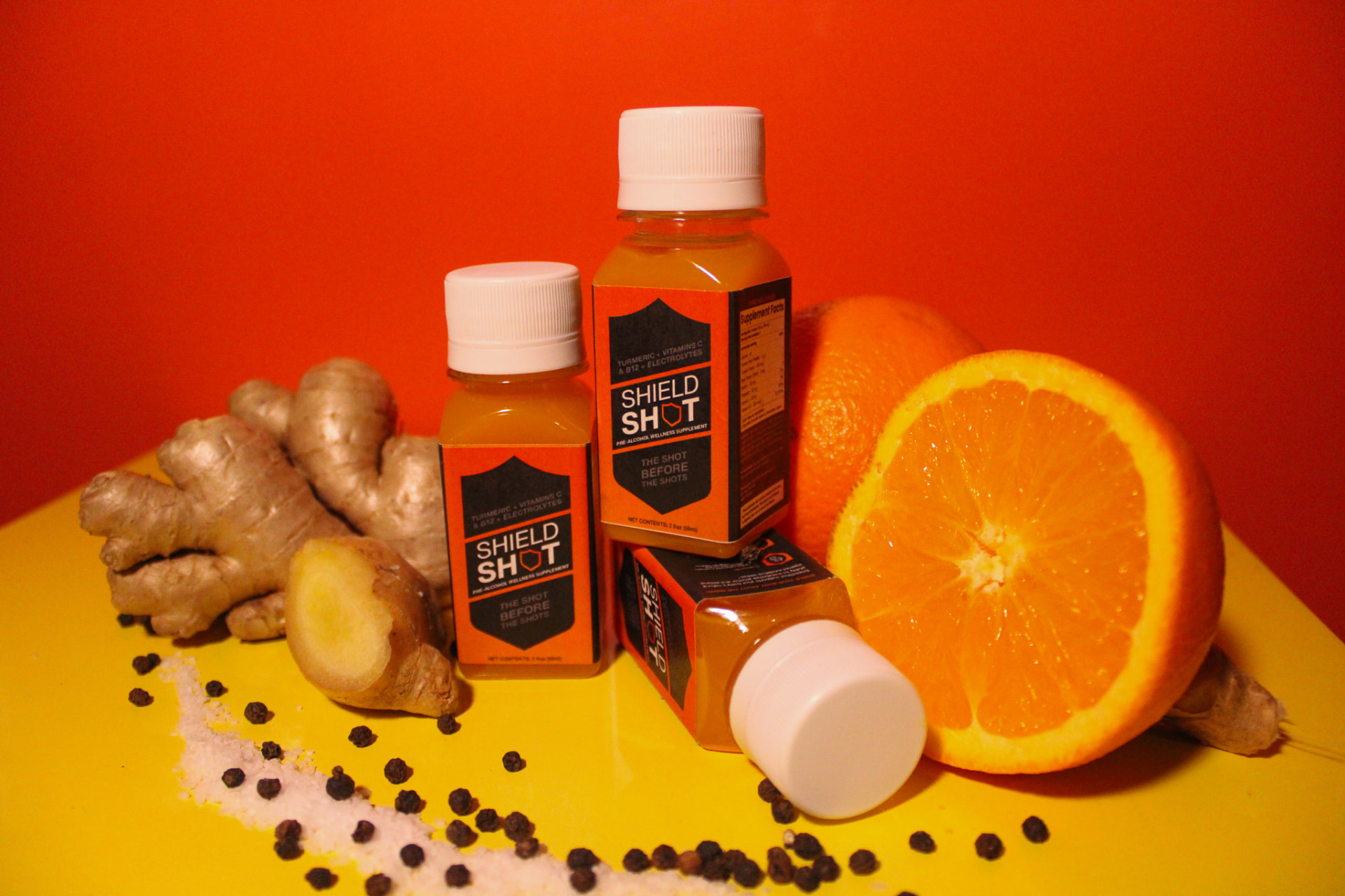 ShieldShot bottles styled with orange, ginger and peppercorns